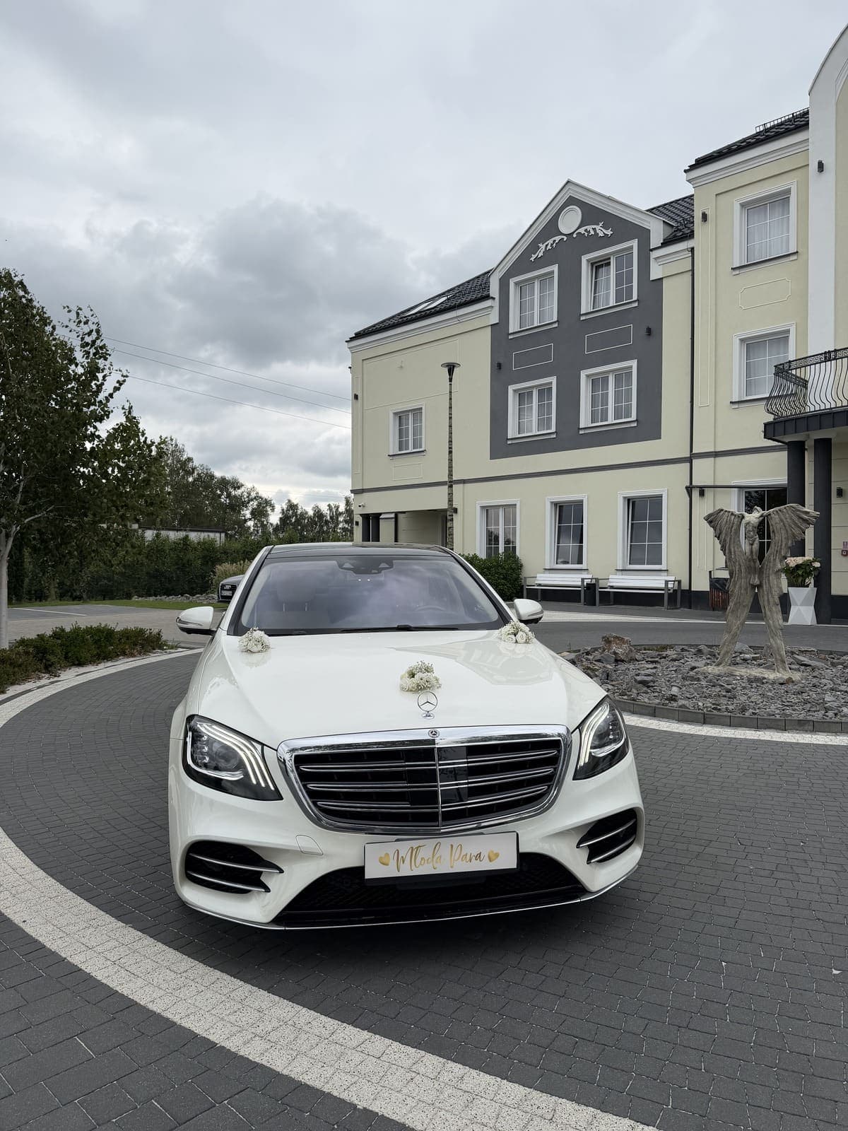 Biały Mercedes-Benz S-Klasa do ślubu przed salą weselną